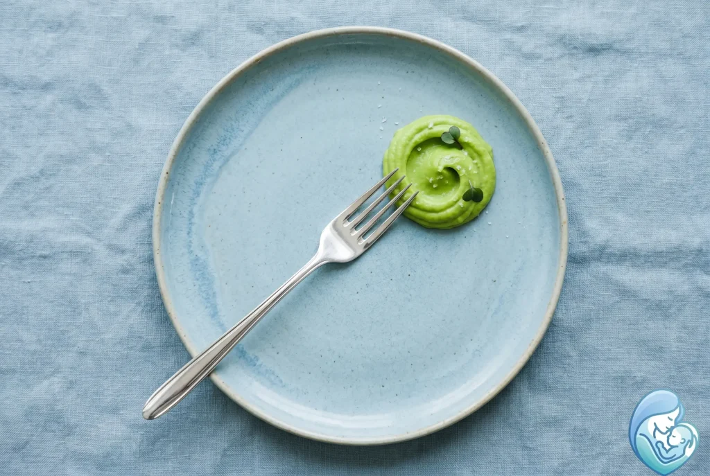 Using a fork to mash baby food avocado